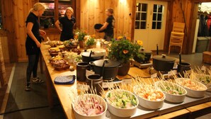 A buffet setup with various food items and cooking equipment.
