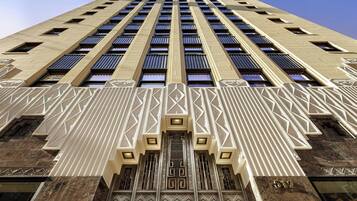 Un edificio alto con fachada simétrica, ventanas amplias y detalles arquitectónicos decorativos.