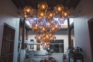 A spacious courtyard with a unique geometric chandelier, white furniture, and a traditional architectural style. - Casa San Miguel Hotel Boutique y Spa (Zacatlán)