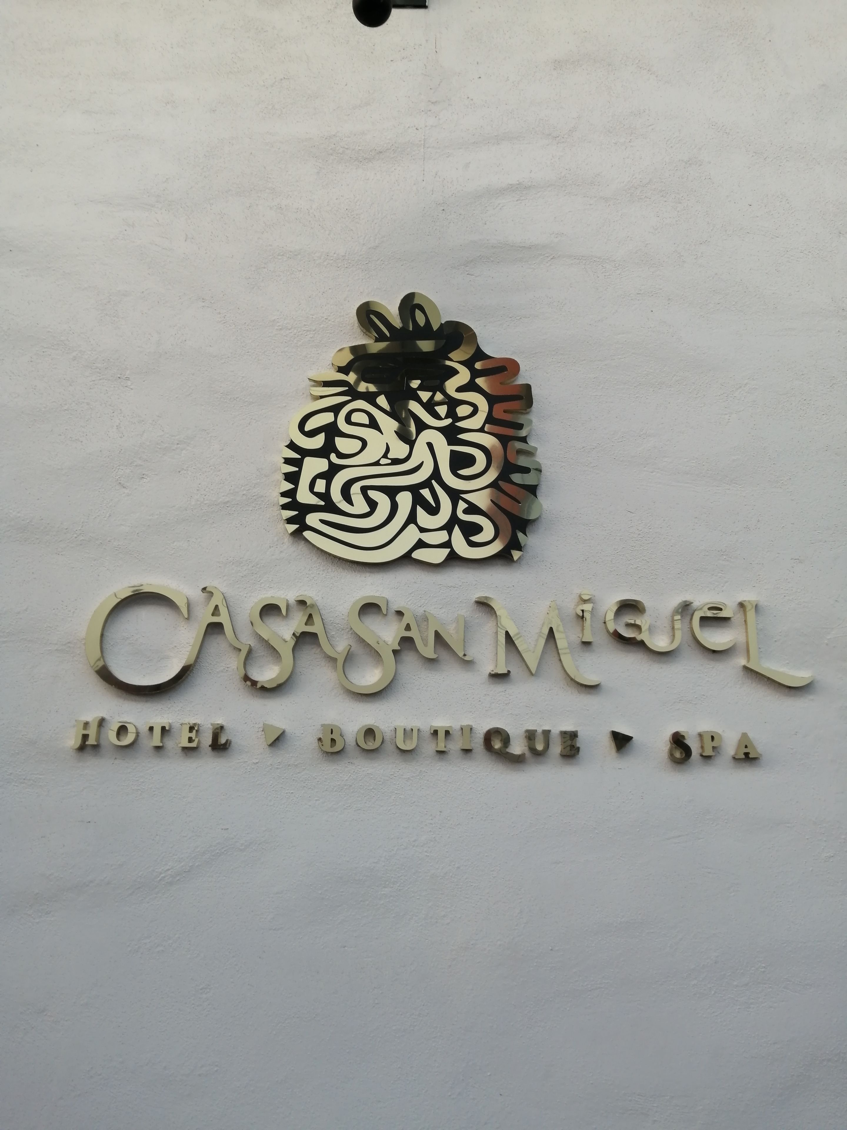 Letrero de 'CASA MIQUEL HOTEL BOUTIQUE SPA' con un emblema decorativo encima del texto.