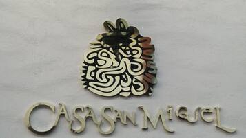 Letrero de 'CASA MIQUEL HOTEL BOUTIQUE SPA' con un emblema decorativo encima del texto.