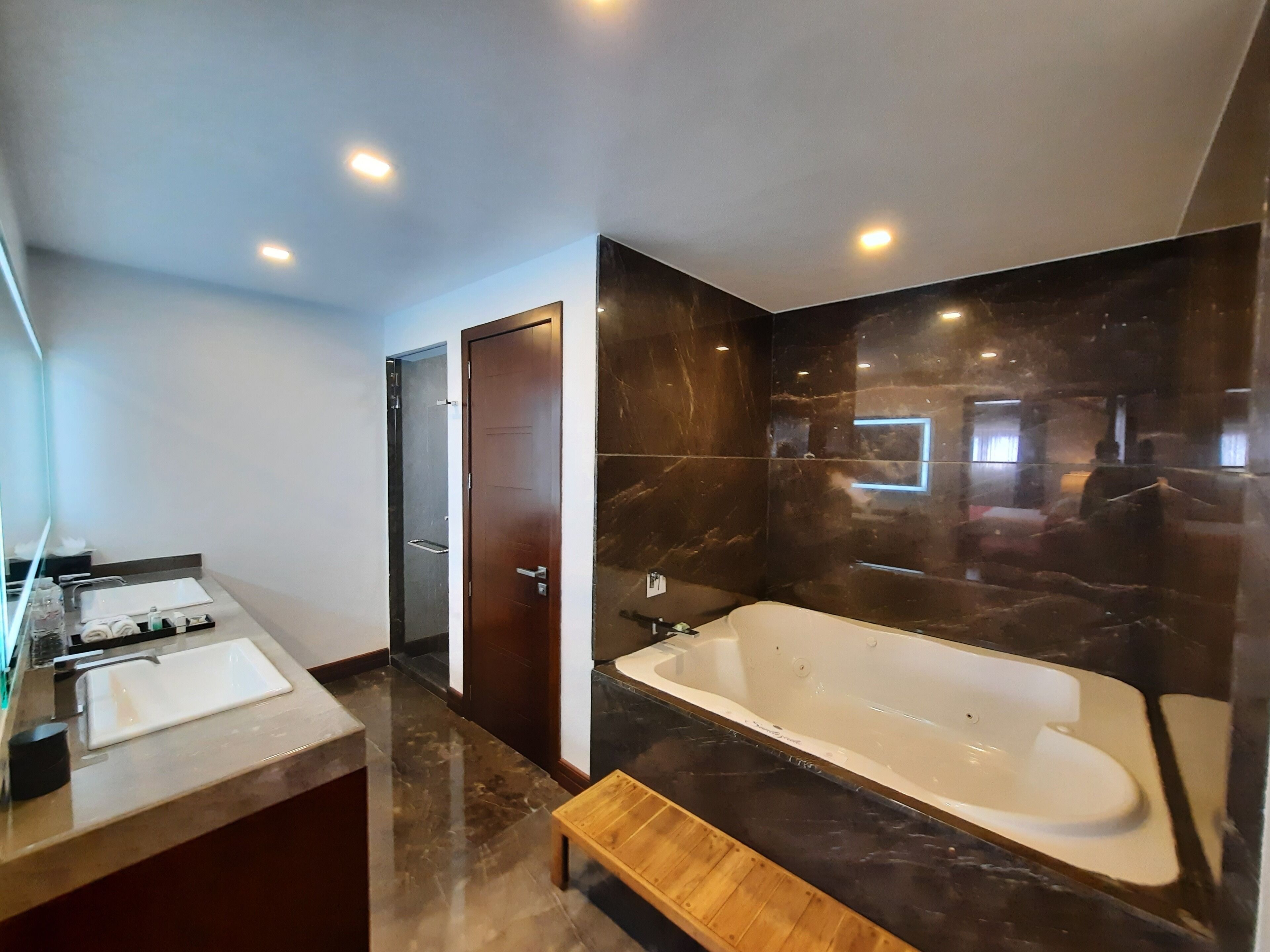 Un baño moderno con una bañera grande, un tocador con espejo y una zona de ducha.