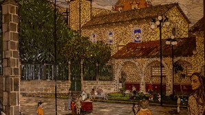 Un patio con suelo de piedra, mobiliario exterior y un edificio con fachada decorada.