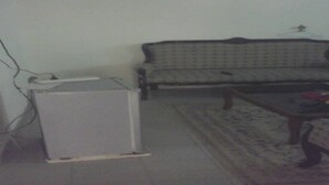 A living room with a sofa, a coffee table, and a white cabinet. - Nella Hotel (Agboville)