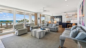 Ein großzügiges Wohnzimmer mit Meerblick, einem Essbereich und einer Küche.