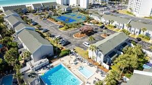 An aerial view of a hotel with multiple buildings, a parking lot, a tennis court, a swimming pool, and a beach view. - South Bay By The Gulf 097 3 Bedroom Townhouse by RedAwning (Destin)