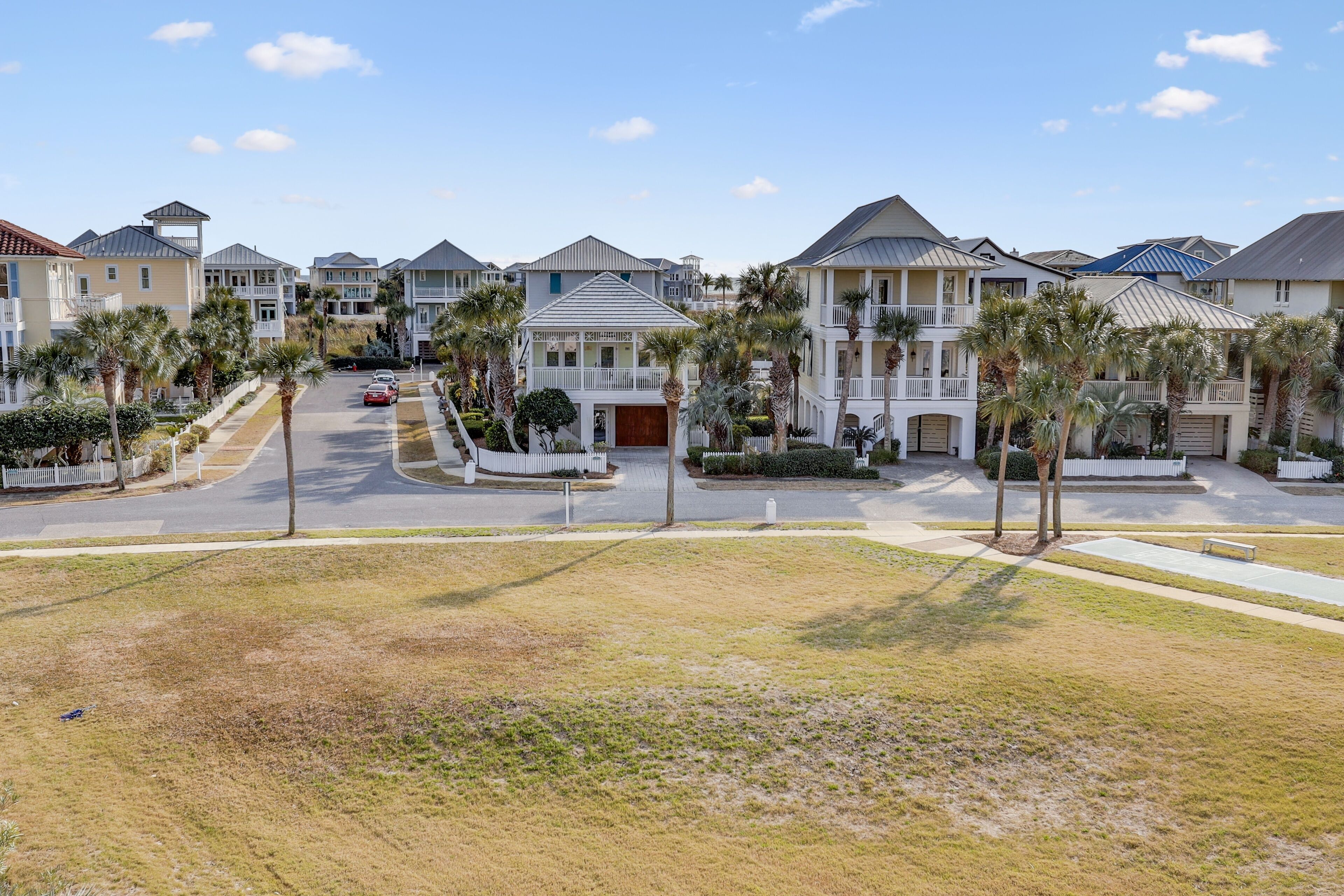 A residential neighborhood with multiple two-story houses, each featuring a front porch and a garage.