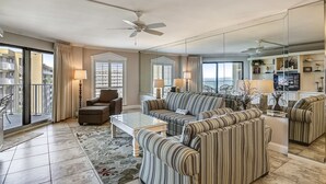 A spacious living room with a large sofa, armchairs, a coffee table, and a balcony with a view. - Inlet Reef 516 2 Bedroom Condo by RedAwning (Destin)