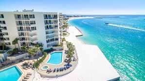 Un resort con varias piscinas, acceso a la playa y vista al océano.