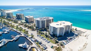 Un hotel costero con varios edificios altos, un puerto deportivo con yates y una playa de arena.