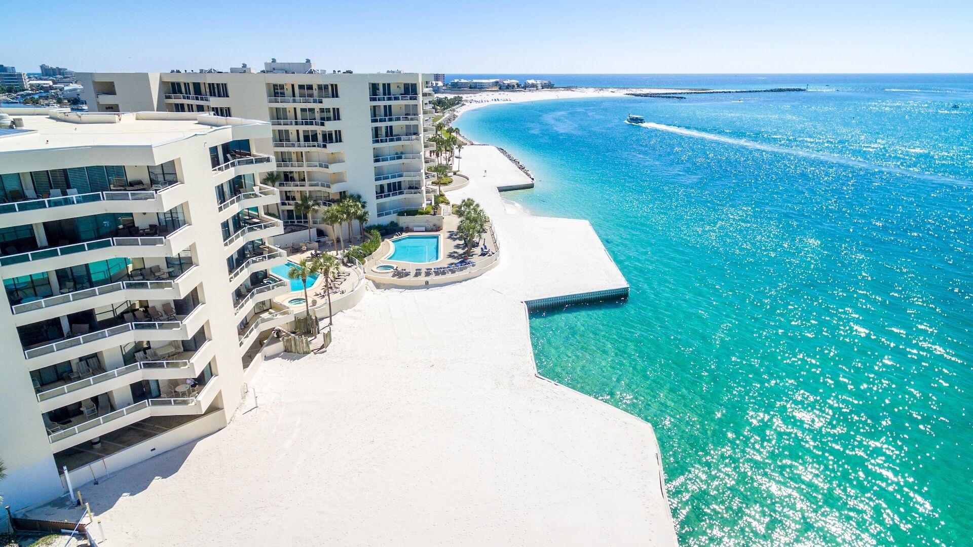 Ein Resort mit Strandlage, mehreren Swimmingpools und einem Sandstrand.