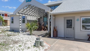 A modern house with a covered porch, a small garden, and a number '4' on the door. - The Other Castle 5 Bedroom Home by RedAwning (Destin)