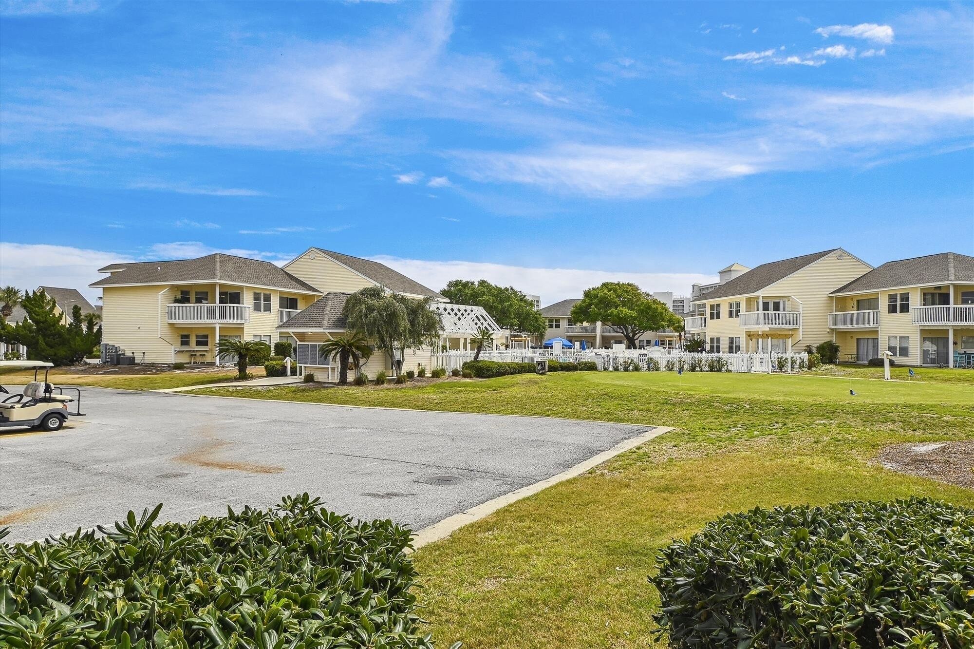 A residential area with two-story buildings, a parking lot, and well-maintained lawns.