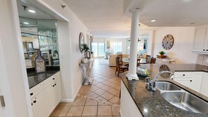 A spacious kitchen with a central island, a dining area with a view, and a living room with a large window. - Inlet Reef 205 2 Bedroom Apts by RedAwning (Destin)
