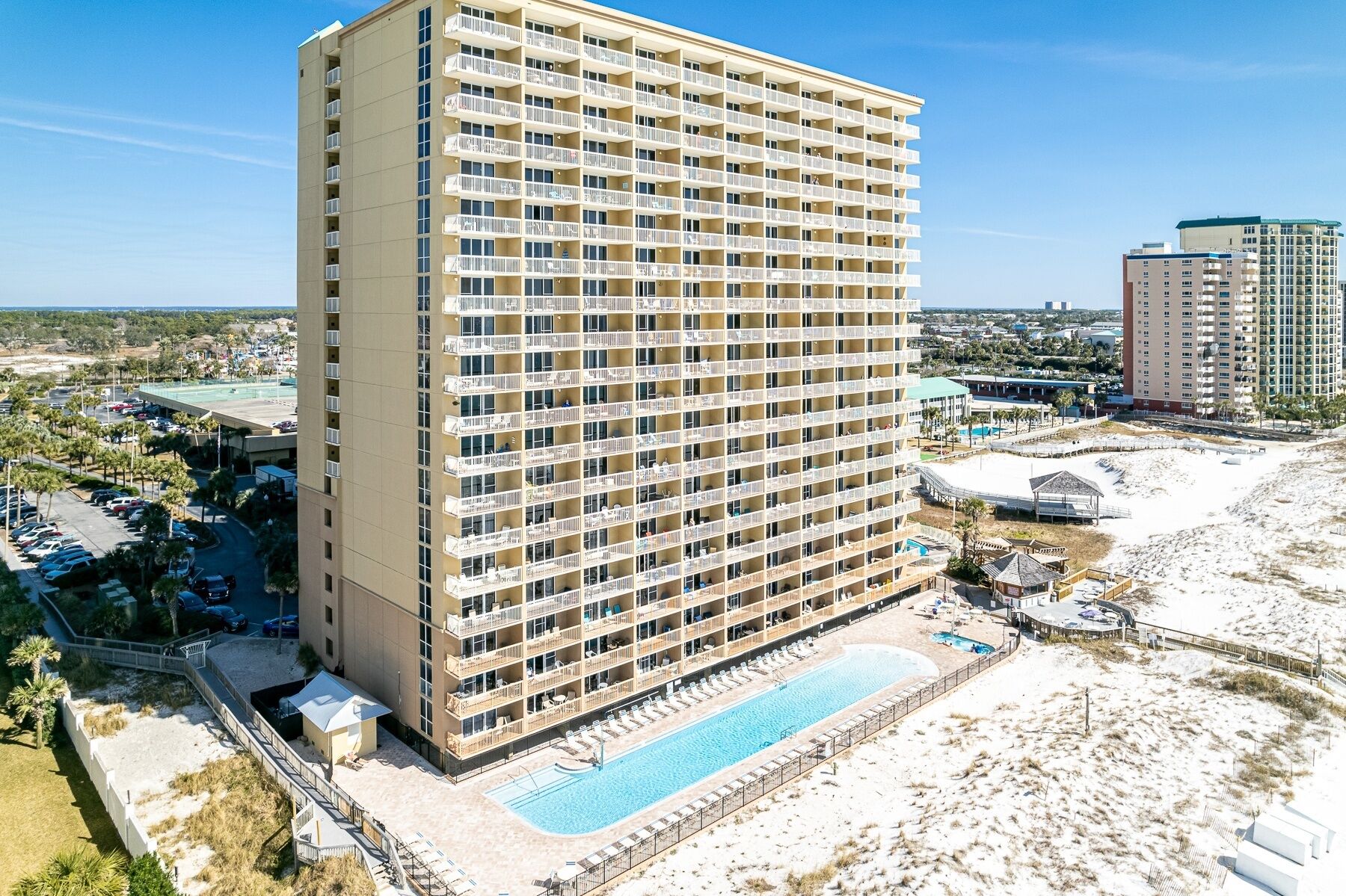 Um hotel moderno com vários sacadões, piscina e zona de praia.