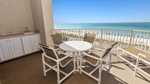 A balcony with a white table and chairs, a sink, and a view of the beach. - Inlet Reef 306 2 Bedroom Condo by RedAwning (Destin)