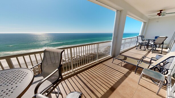 A balcony with a view of the ocean, furnished with chairs and a table. - Oceania 906 3 Bedroom Condo by RedAwning (Destin)