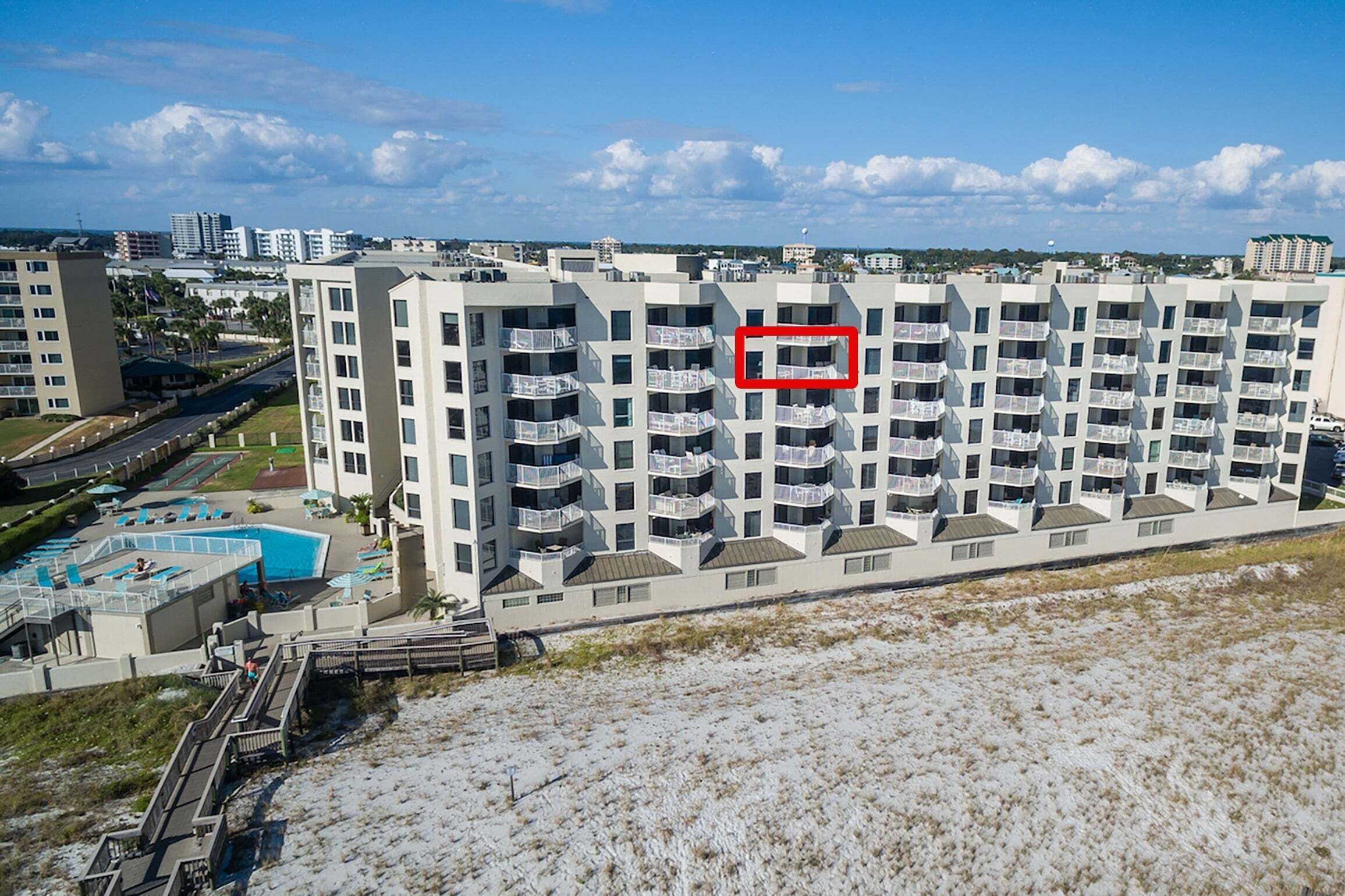 Un hôtel à plusieurs étages doté de balcons, d’une piscine et offrant une vue sur la plage.