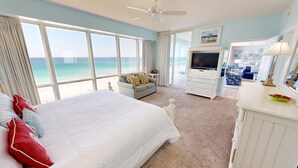 A hotel room with a large bed, a TV, a sofa, and a view of the ocean. - Oceania 607 3 Bedroom Condo by RedAwning (Destin)
