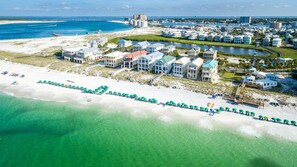 An aerial view of a coastal resort with beachfront villas, a marina, and a bridge connecting to the mainland. - Magnolia House 112 2 Bedroom Condo by RedAwning (Destin)