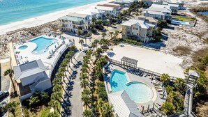 Een kustresort met meerdere zwembaden, villa's direct aan het strand en een zandstrand.