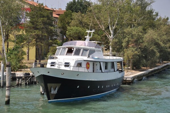 A boat docked at a pier with a building in the background.