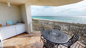 Un balcon avec une table et des chaises, un évier et une vue sur l’océan.