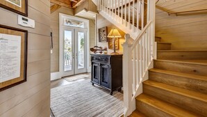 Un escalier en bois avec une rampe blanche menant à l’étage supérieur.
