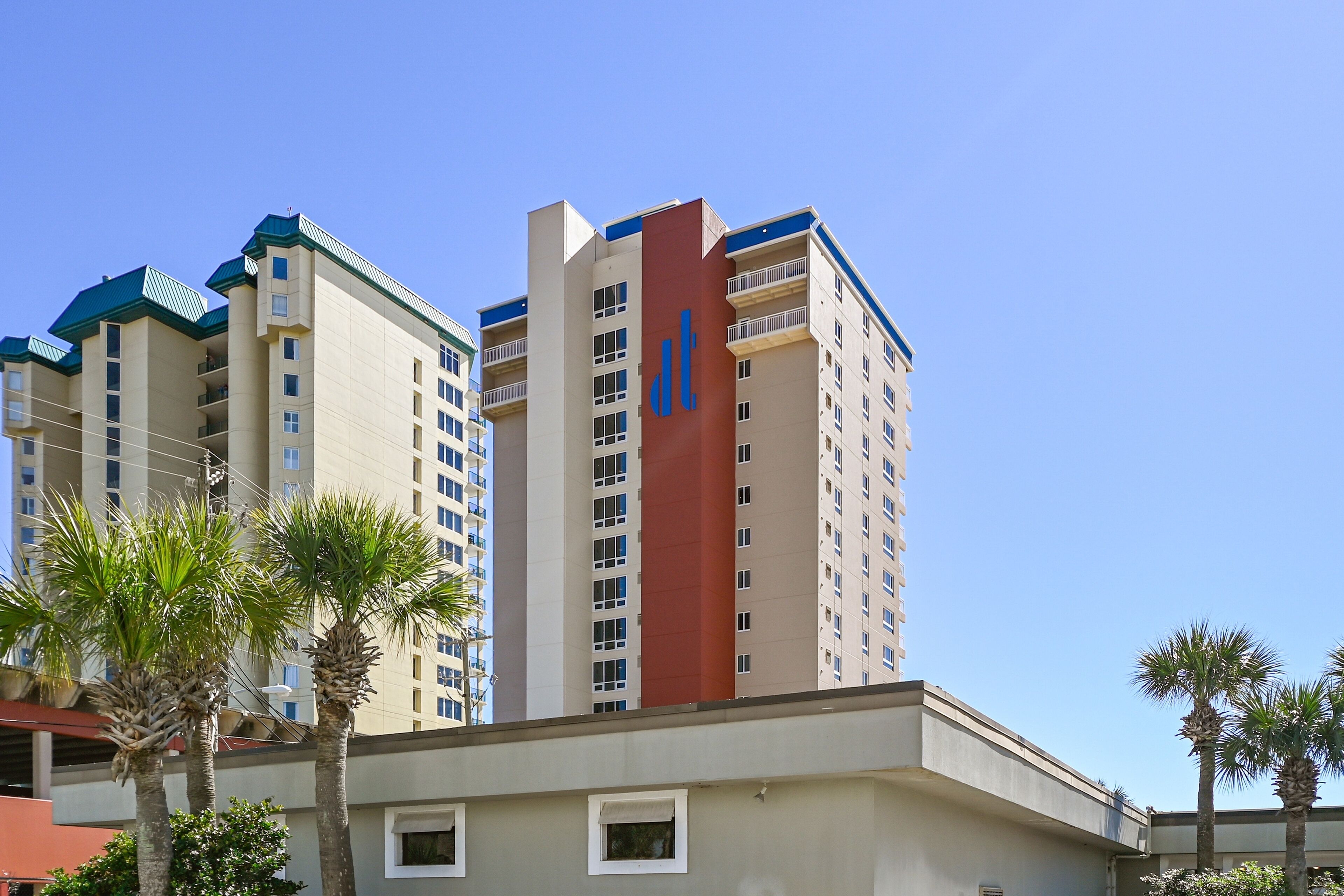 Un hôtel de grande hauteur, avec de nombreux étages, des balcons et un logo bien visible sur le côté.