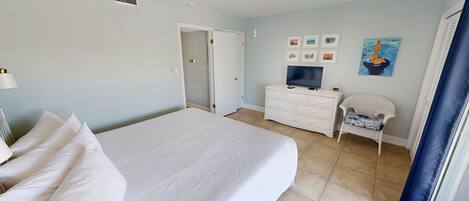 A hotel room with a bed, a dresser, a television, and a chair.