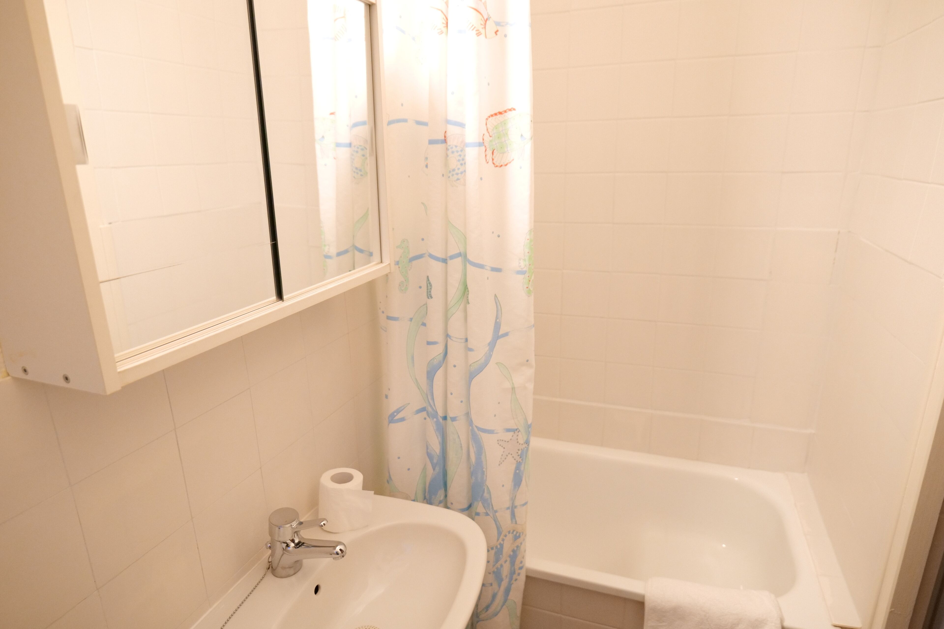 Een badkamer met een wastafel, toilet en bad.