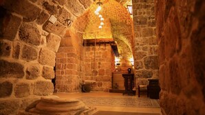 A stone-walled interior with a staircase leading to a higher level. - Zidan Sarai Suite (Acre)