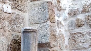 Un pilar de piedra en una esquina con suelo de baldosas.