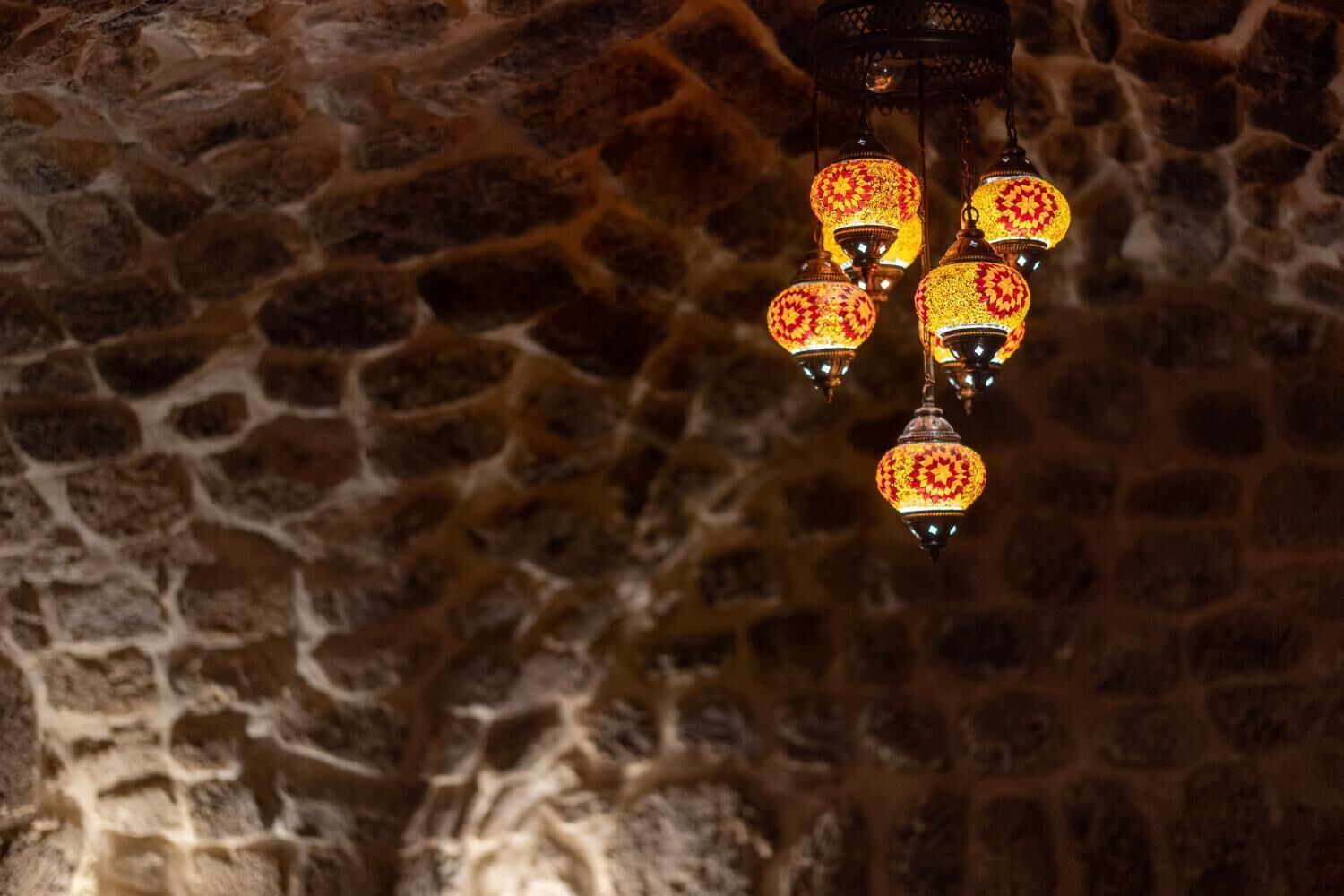 A stone wall with hanging lanterns.