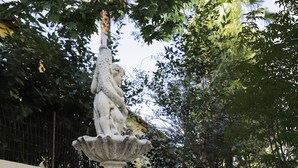 Ein Steinkunstwerk mit Statue in einem Garten.