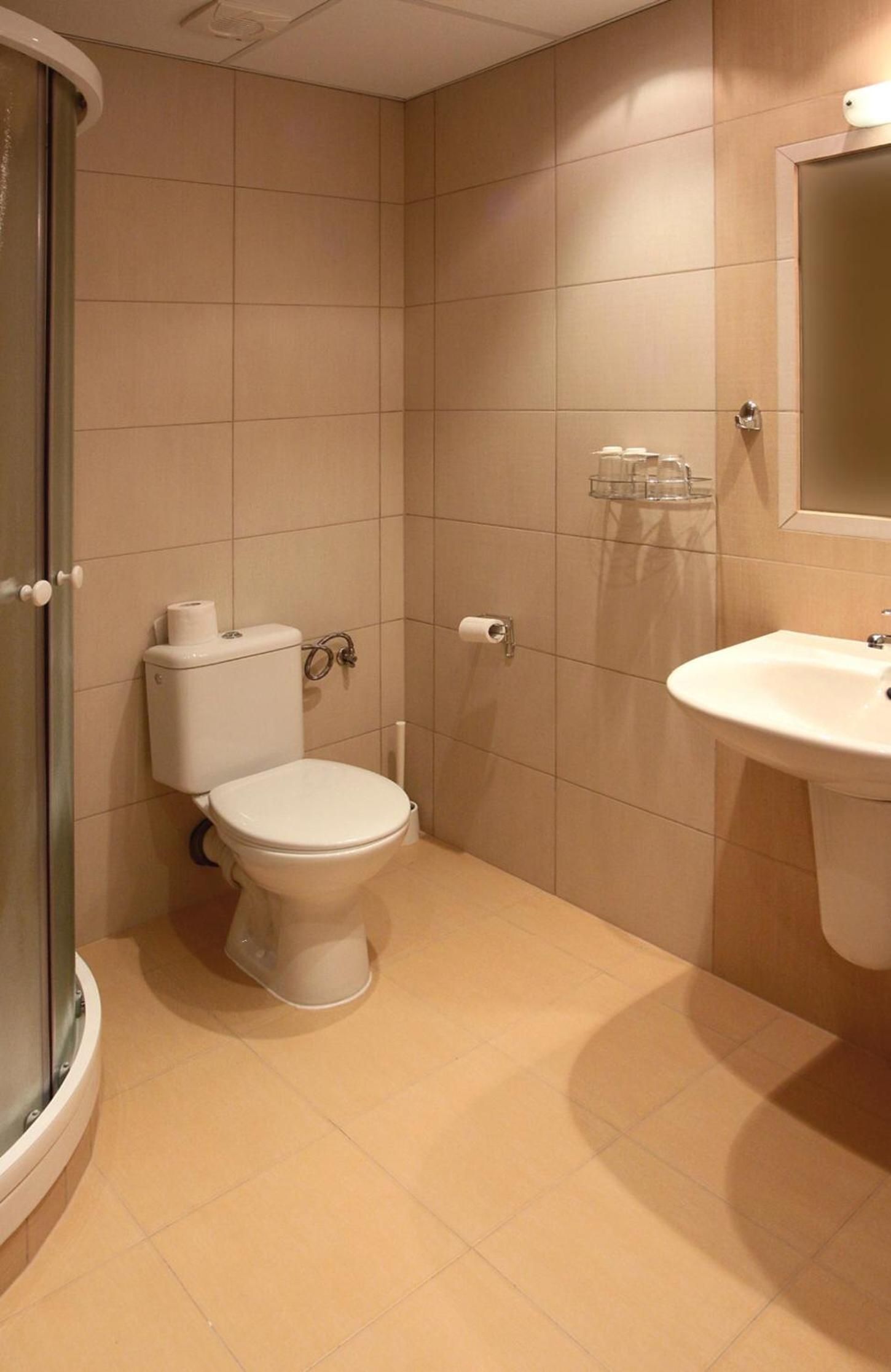A bathroom with a toilet, a sink, and a shower.