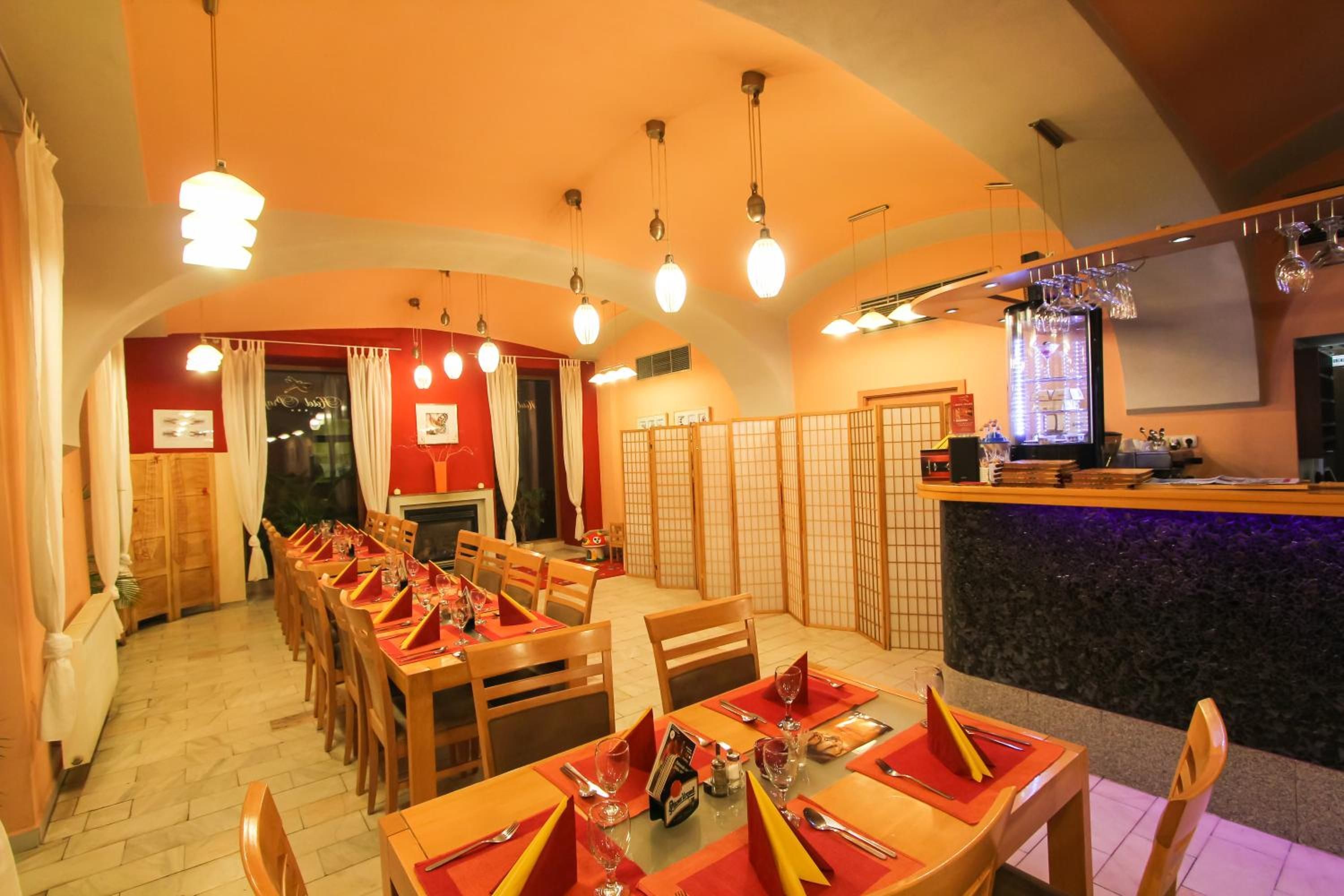 A restaurant with multiple dining tables, chairs, and a bar area.