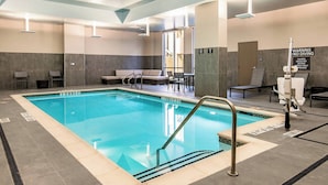 Una piscina interior con carriles claramente marcados, una zona de vestuarios y un área de descanso con vistas al exterior.