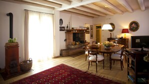 A cozy living room with a fireplace, wooden furniture, and a television. - B&B Casa Fabbris (Sandrigo)
