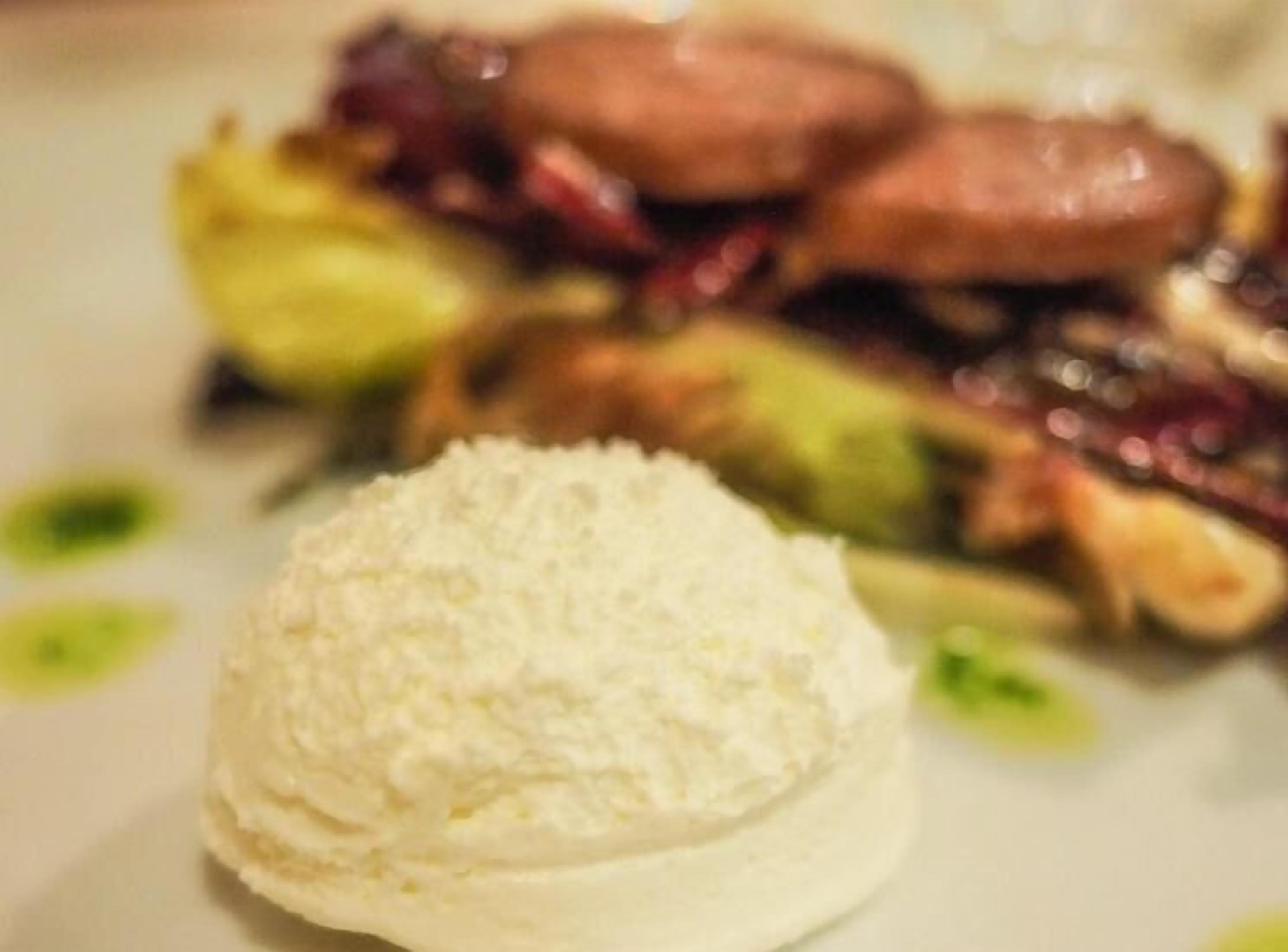 Un plato de postre con una porción de helado y una variedad de frutas y verduras.