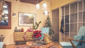 A cozy living room with a sofa, a coffee table with decorative items, a Christmas tree, and a framed picture on the wall. - Hotel Ristorante Due Platani (Cornedo Vicentino)