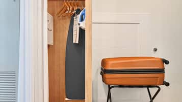 A room with a wooden wardrobe, a suitcase, and a radiator.