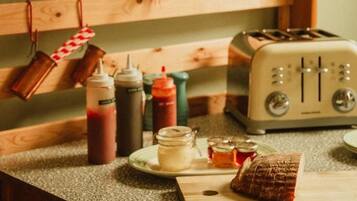 A kitchen with wooden cabinets, a toaster, and various condiments on the counter.