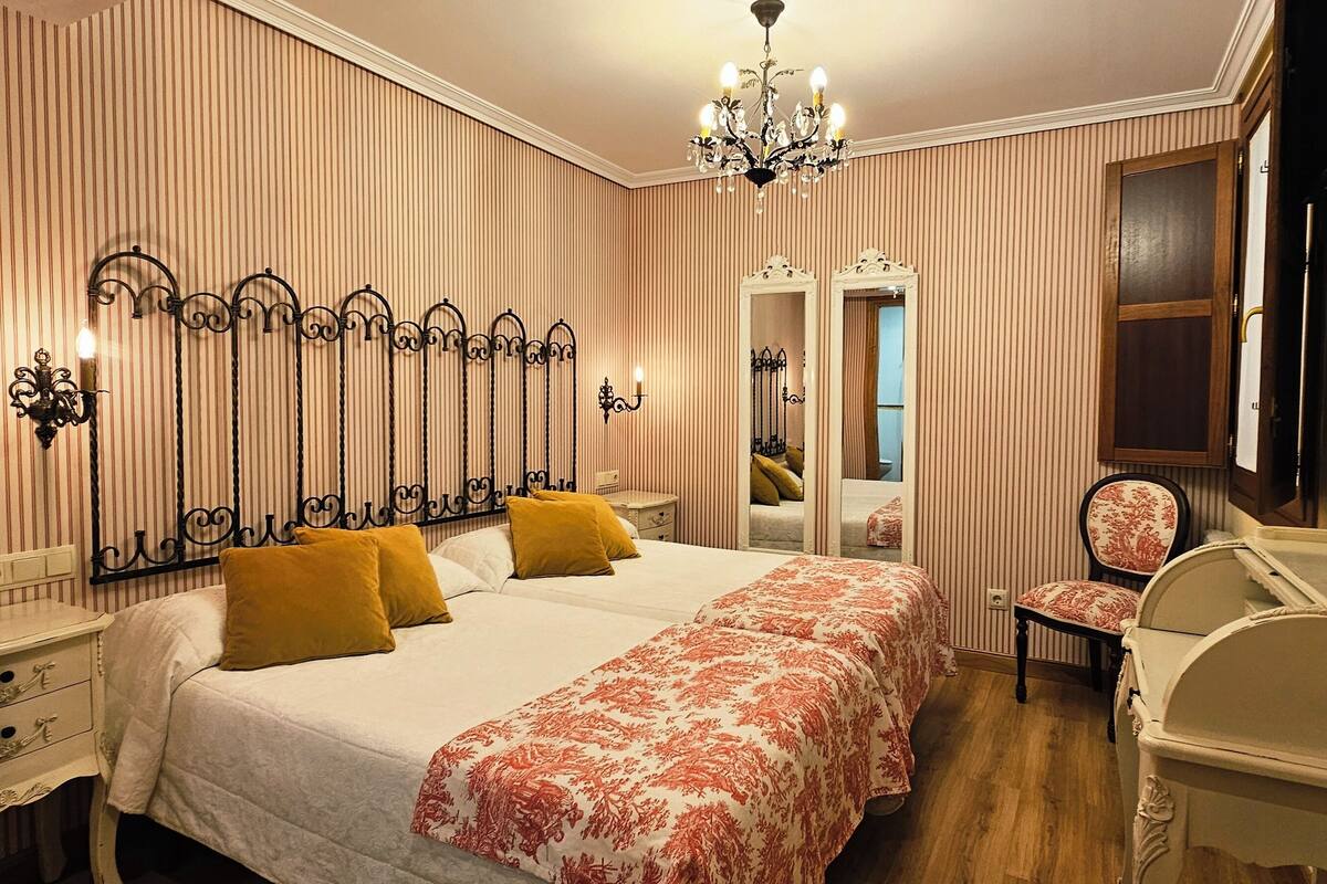 Een hotelkamer met een groot bed, een stoel, een kaptafel en een spiegel.