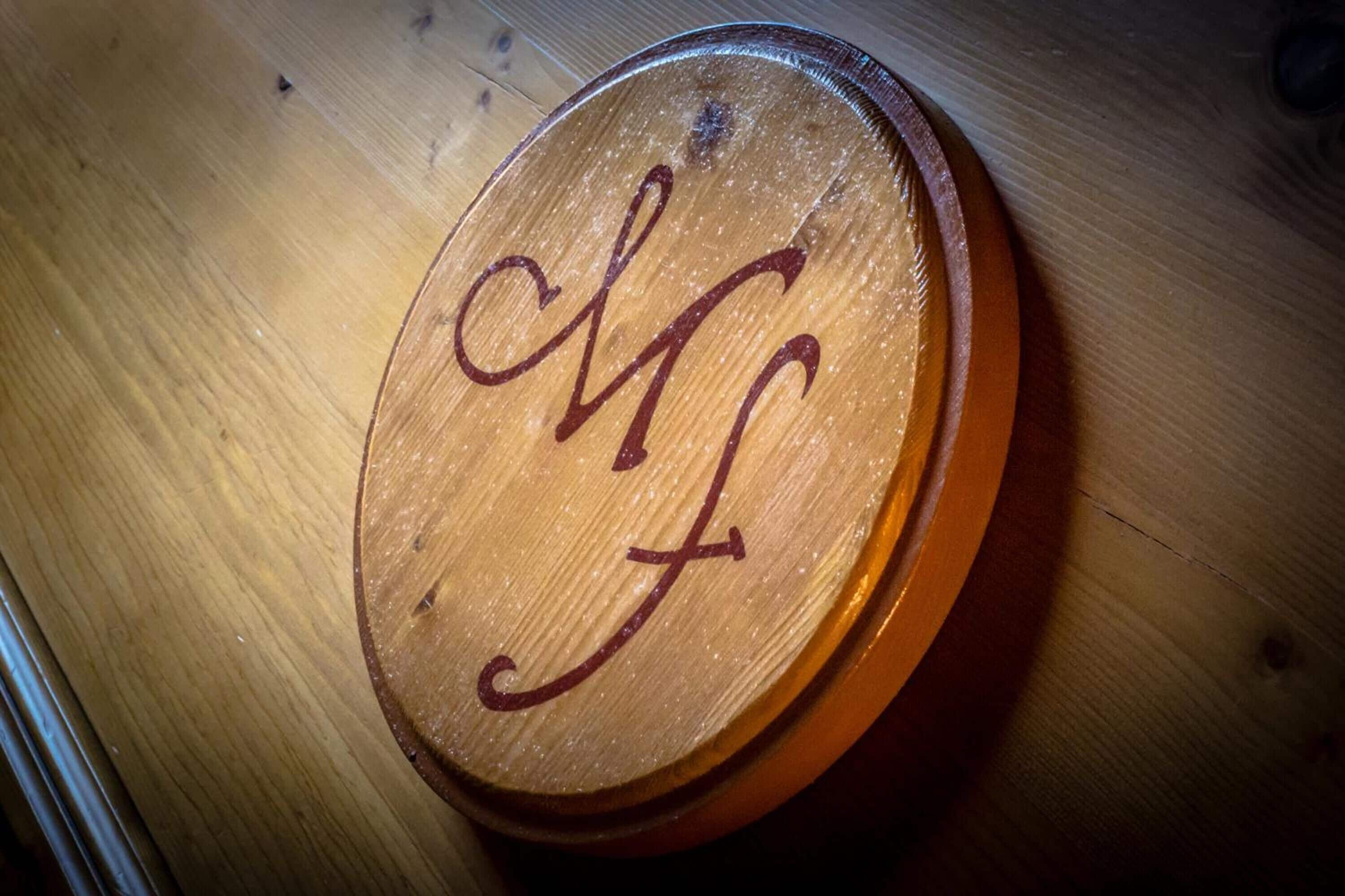 Una placa de madera con las iniciales "MF" grabadas.