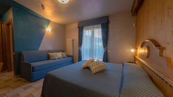 Un dormitorio con cama, sofá y cabecera de madera.