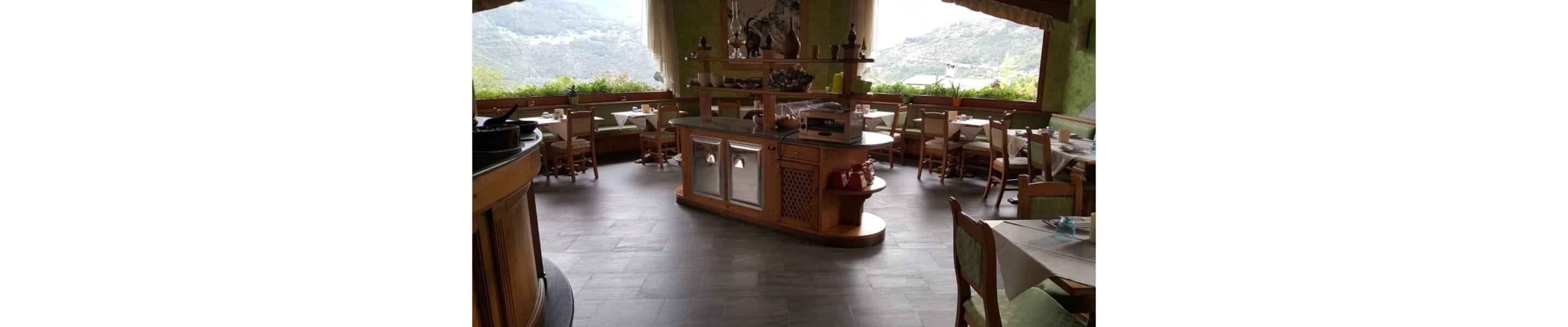 Un restaurante con barra central, varias zonas de estar y vistas a las montañas.