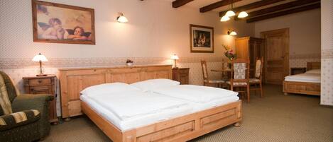 A bedroom with a wooden bed, two bedside tables with lamps, a chair, and a wooden wardrobe.