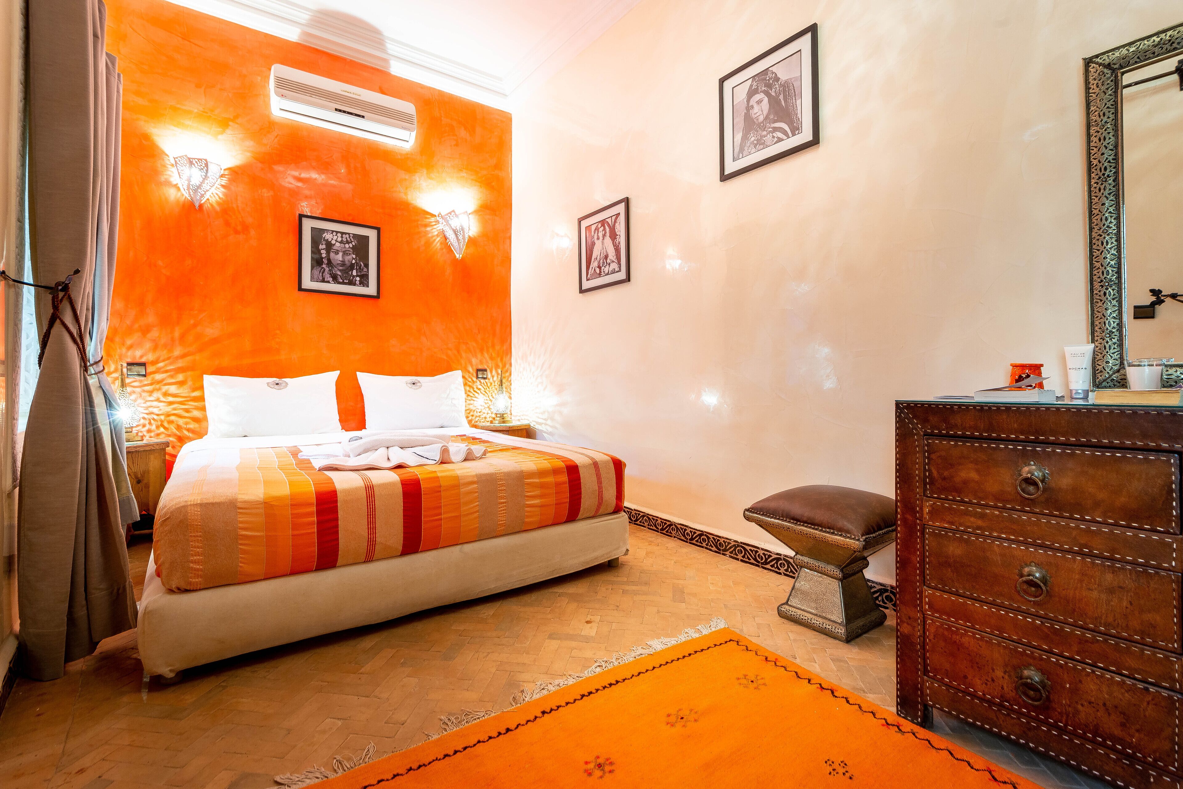 Una habitación con cama, cómoda y espejo.