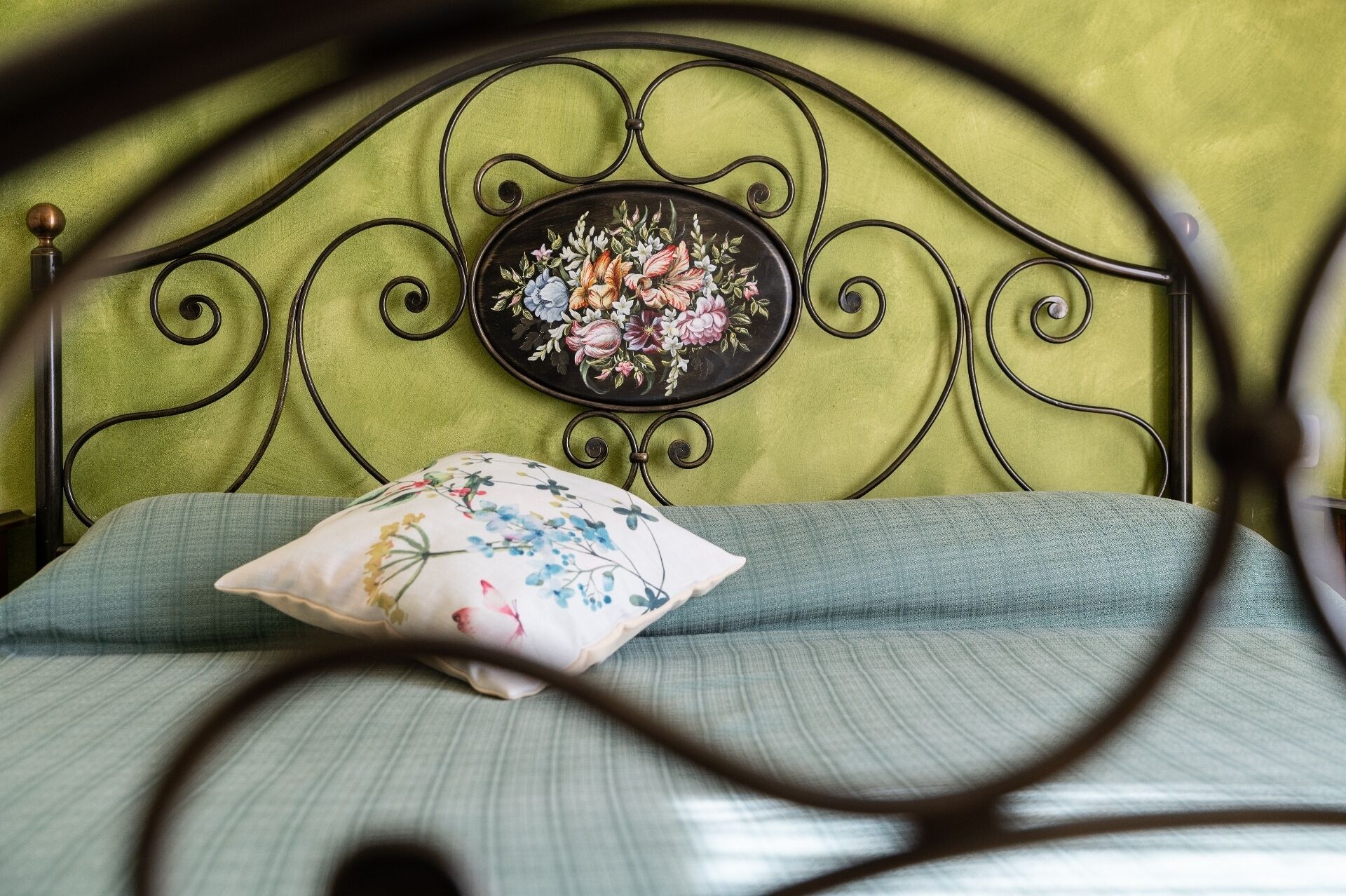 A bed with a floral headboard and a pillow with a floral pattern.